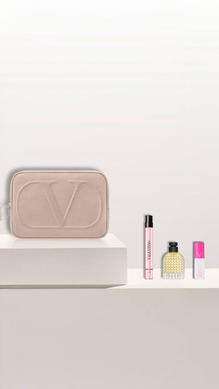 Valentino Beauty-Set: pinke Tasche, Parfums und Lippenprodukt auf Weiß.
