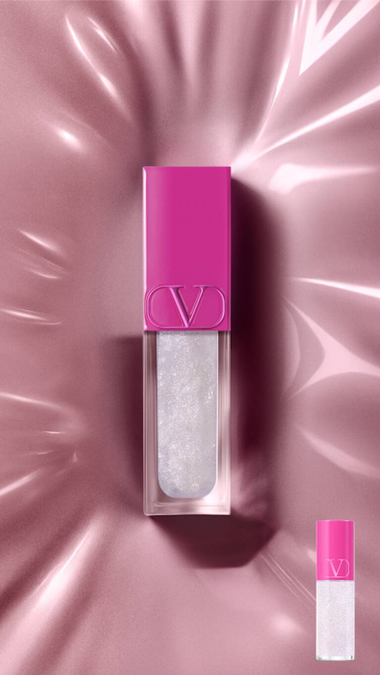 Ein Valentino Lipgloss mit fuchsiafarbener Kappe und schimmerndem weißem Gloss steht auf einer reflektierenden pinkfarbenen Oberflache. Eine kleinere Version ist unten rechts.