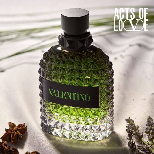 Grunes Parfum in einer facettierten Flasche auf einem eleganten Hintergrund mit Lavendel und Gewurzen.